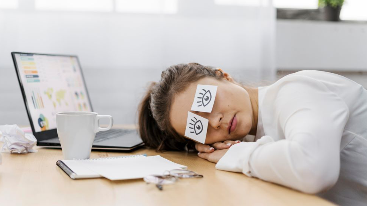 Tired businesswoman covering her eyes with drawn eyes paper